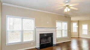A spacious living room with hardwood floors, a fireplace, and large windows. - Spacious Brick Home in Acworth – Perfect Family Getaway (Acworth)