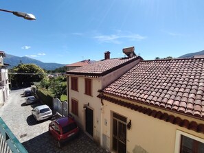 A residential building with a tiled roof, a parked car, and a street lamp.