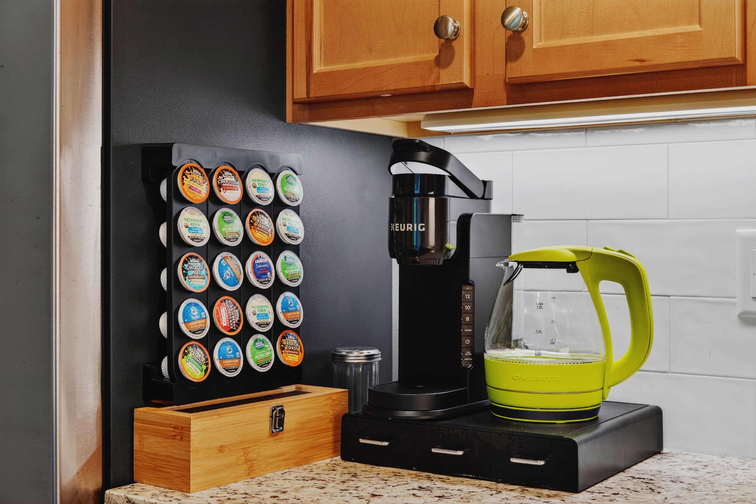 Eine Kaffeemaschine, ein Keurig-Gerät und ein grüner Kaffeekocher auf einer Küchenarbeitsplatte.