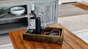 Un plateau en bois avec des bouteilles et des verres sur une table.