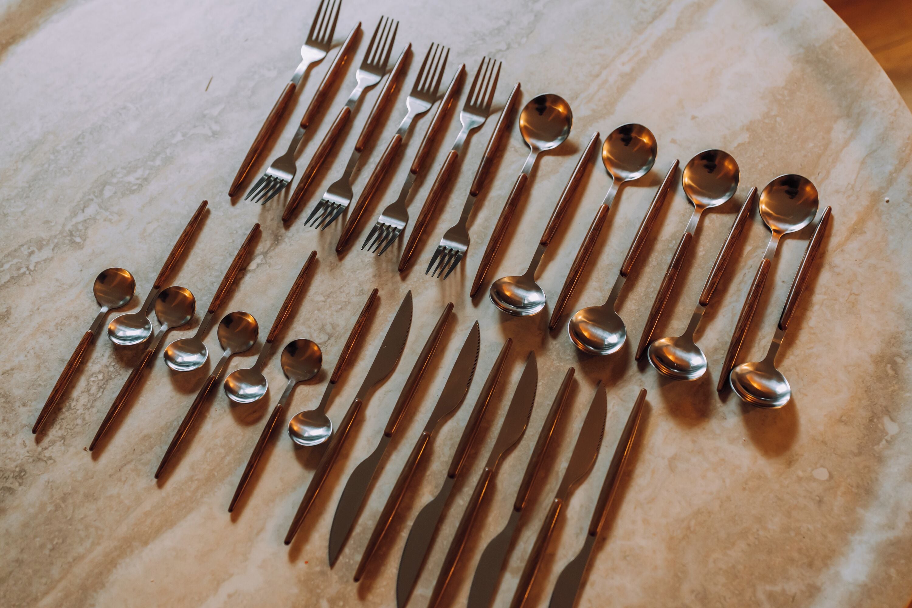A set of cutlery arranged on a marble surface.
