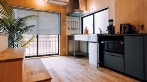 Uma cozinha moderna com piso de madeira, forno embutido e cafeteira.