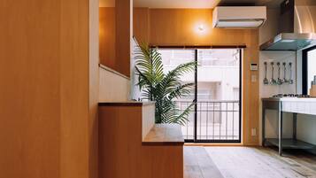 A modern kitchen with wooden cabinetry, a built-in stove, and a potted plant.