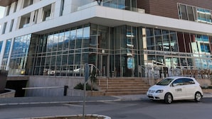Ein mehrstöckiges Hotel mit auffälligem Logo an der Fassade, großen Glasfenstern und einem modernen architektonischen Design.