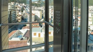 Ein Aufzug mit Blick auf eine Skyline durch große Fenster.