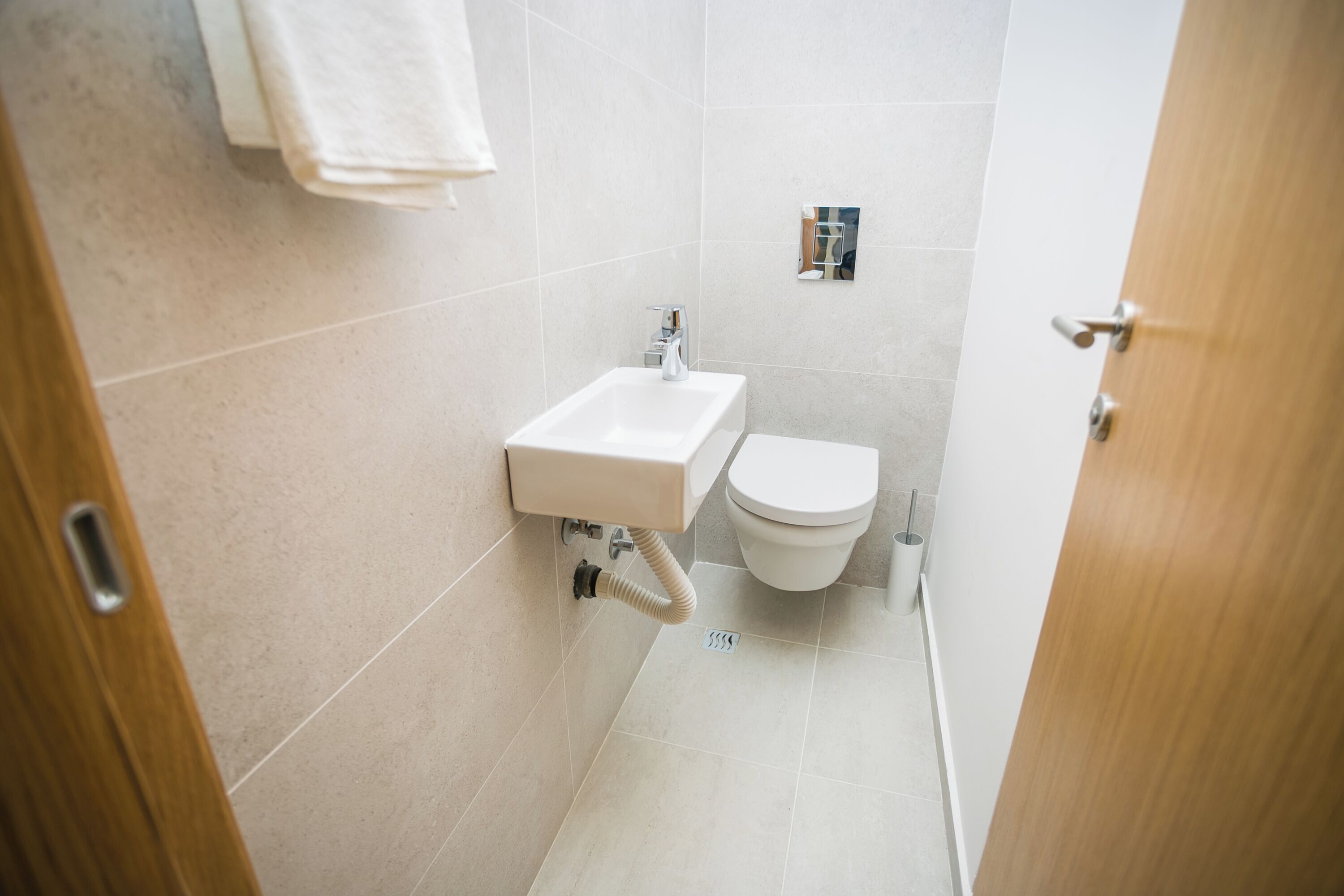 A small bathroom with a sink, toilet, and a towel rack.