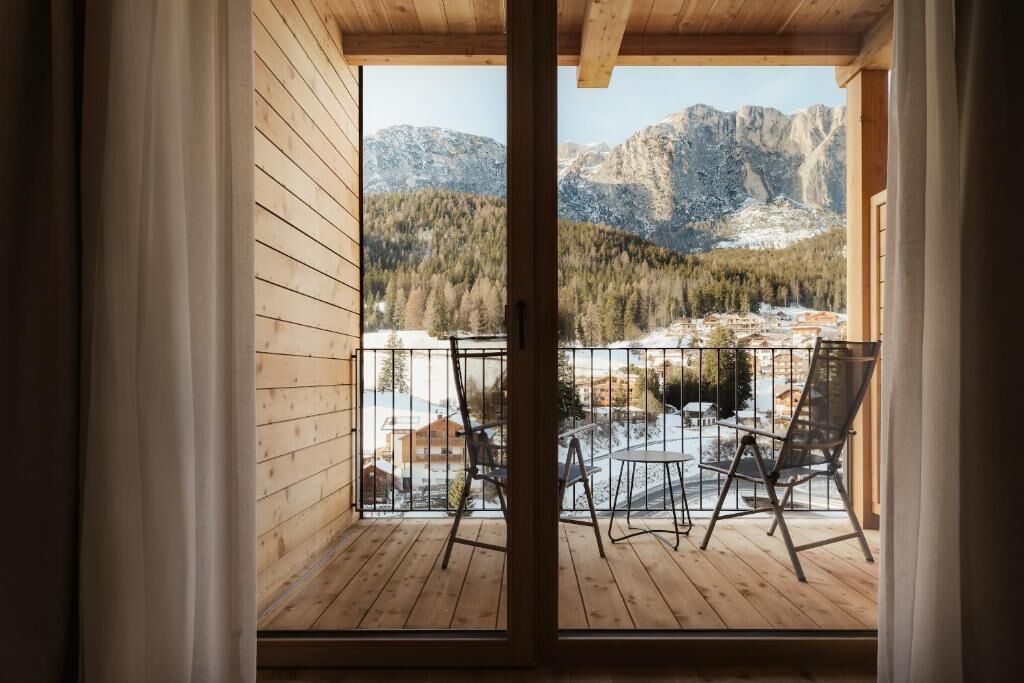 A wooden balcony with a view of a mountainous landscape.