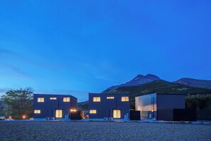 Un edificio moderno con techo plano, ventanas rectangulares y suelo de grava.