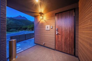 Entrada moderna de hotel con un muro de madera, una puerta y un cartel que indica el número de habitación.