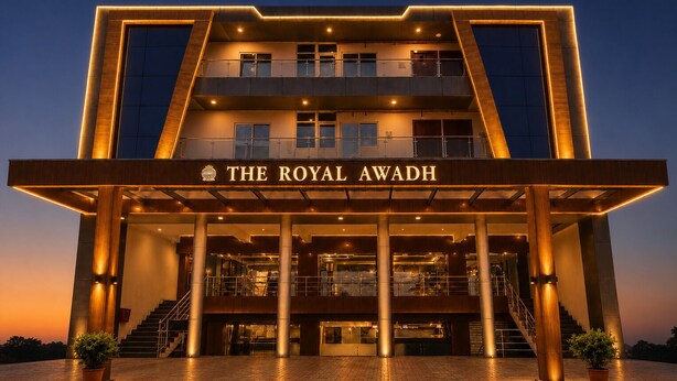 Un hotel de varios pisos con una entrada destacada, un letrero que dice 'The Royal Awadh' y una escalera que lleva a los pisos superiores.