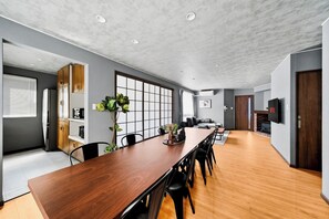 Eine moderne Küche mit Holzschränken, einem eingebauten Backofen und einem großen Fenster.