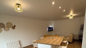 Een moderne eethoek met een houten tafel, witte stoelen en een ingebouwde witte kast.