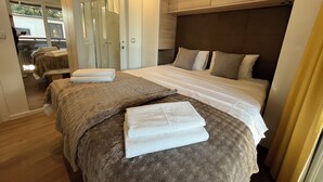 A hotel room with two beds, a large mirror, and a wooden headboard.