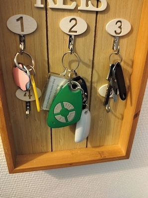 A wooden key holder with numbered slots labeled 1, 2, and 3.