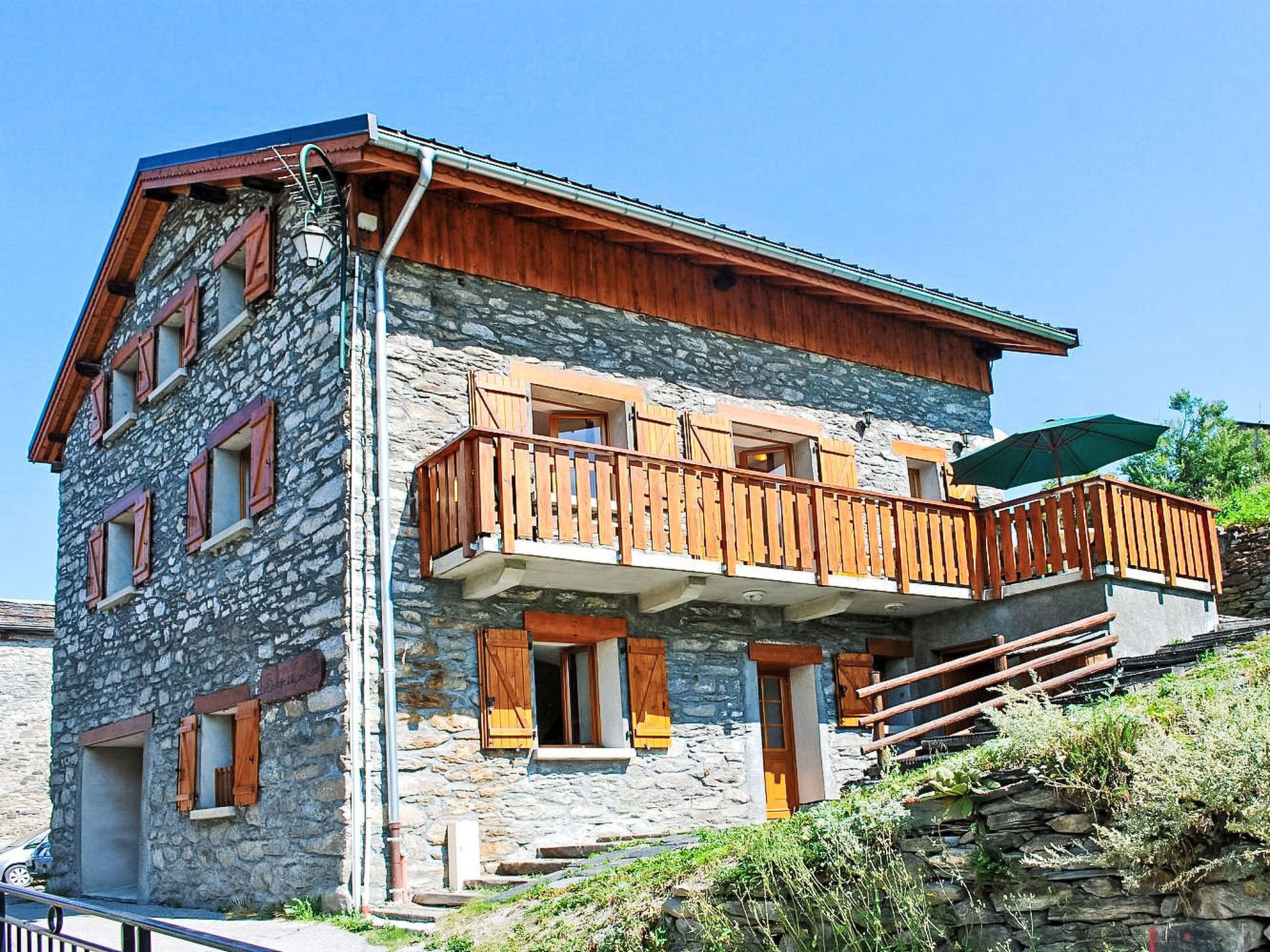 Un edificio de varios pisos de piedra con balcones de madera y una escalera que conduce al piso superior.