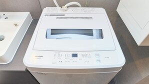 A white washing machine with a control panel, a water inlet, and a drain. - J-ARC Kamata (Ota-ku)