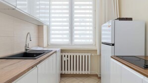 Una cocina con pileta, estufa y refrigerador.