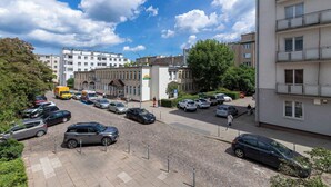 Un estacionamiento con coches, un edificio con balcones y un cielo despejado.