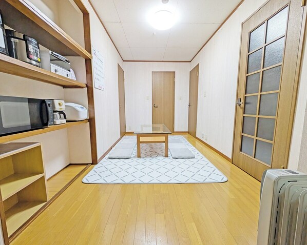 A narrow hallway with wooden flooring, a glass table, and a microwave on a shelf. - Coco Stay 5minute walk from Kuroiso Station 2LD / Nasushiobara City Tochigi (Nasushiobara City)