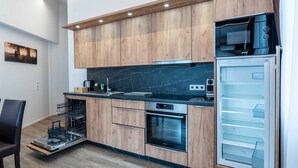 Una cocina moderna con armarios de madera, horno empotrado, microondas y lavavajillas.