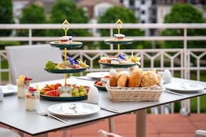 Una mesa de buffet con diversos alimentos y una cesta de mimbre para pan.