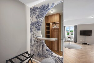 Una habitación moderna con un armario de madera, un televisor y vistas al exterior.