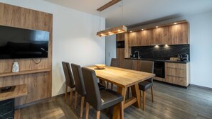 Een moderne keuken met houten kastjes, een ingebouwde oven en een zwart marmeren aanrecht.