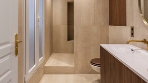 Een moderne badkamer met een witte wastafel, houten opbergmeubel en een grote spiegel.