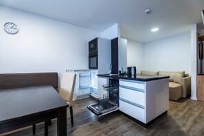 A compact kitchen with a built-in dishwasher, a microwave, and a refrigerator. - Maiskogelblick Apartments - TOP 11 (Piesendorf)