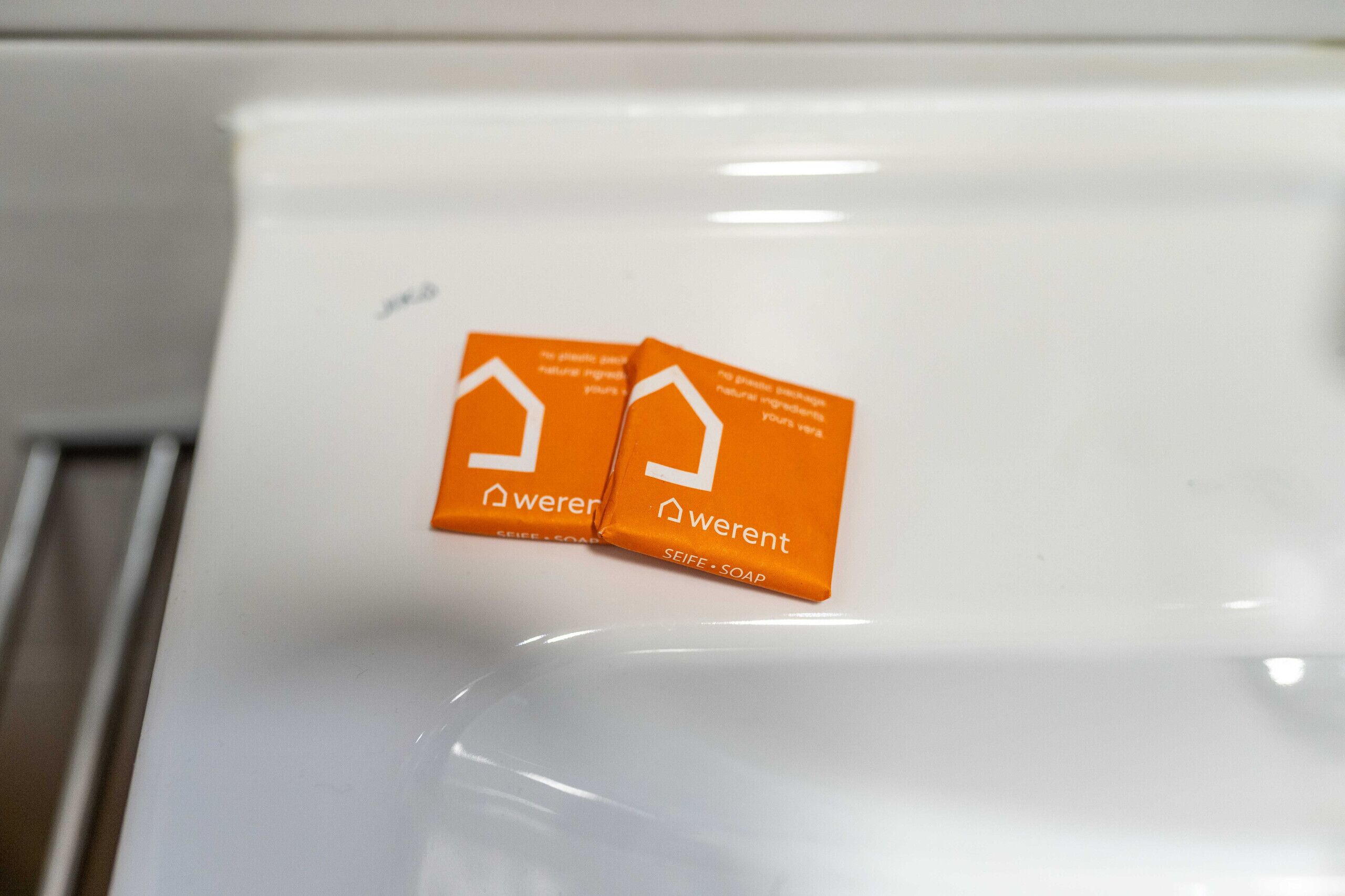 Two orange labels on a white surface, likely a sink or countertop.