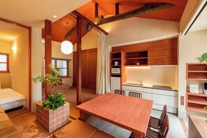 Eine moderne Küche mit Holdekor, einem Essbereich mit Holztisch und -stühlen sowie einem kleinen, weißen Kühlschrank.