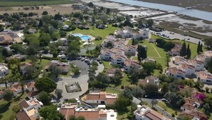 Vista aerea di una zona residenziale con case, una piscina e un'ampia distesa d'acqua.