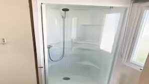 Een douchecabine met glazen wanden en een handdouche.