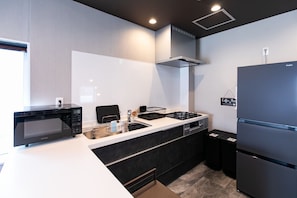 Eine moderne Küche mit Mikrowelle, Herd, Spüle und Kühlschrank.