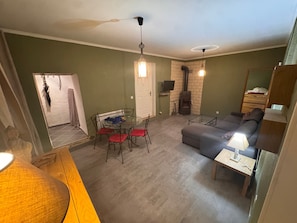 Una sala de estar con un sofá, una mesa de centro de vidrio, una chimenea y un comedor con sillas y una mesa.