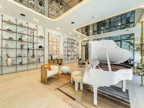 Ein geräumiges Wohnzimmer mit einem Flügel, hohen Decken und einem modernen Interieur.