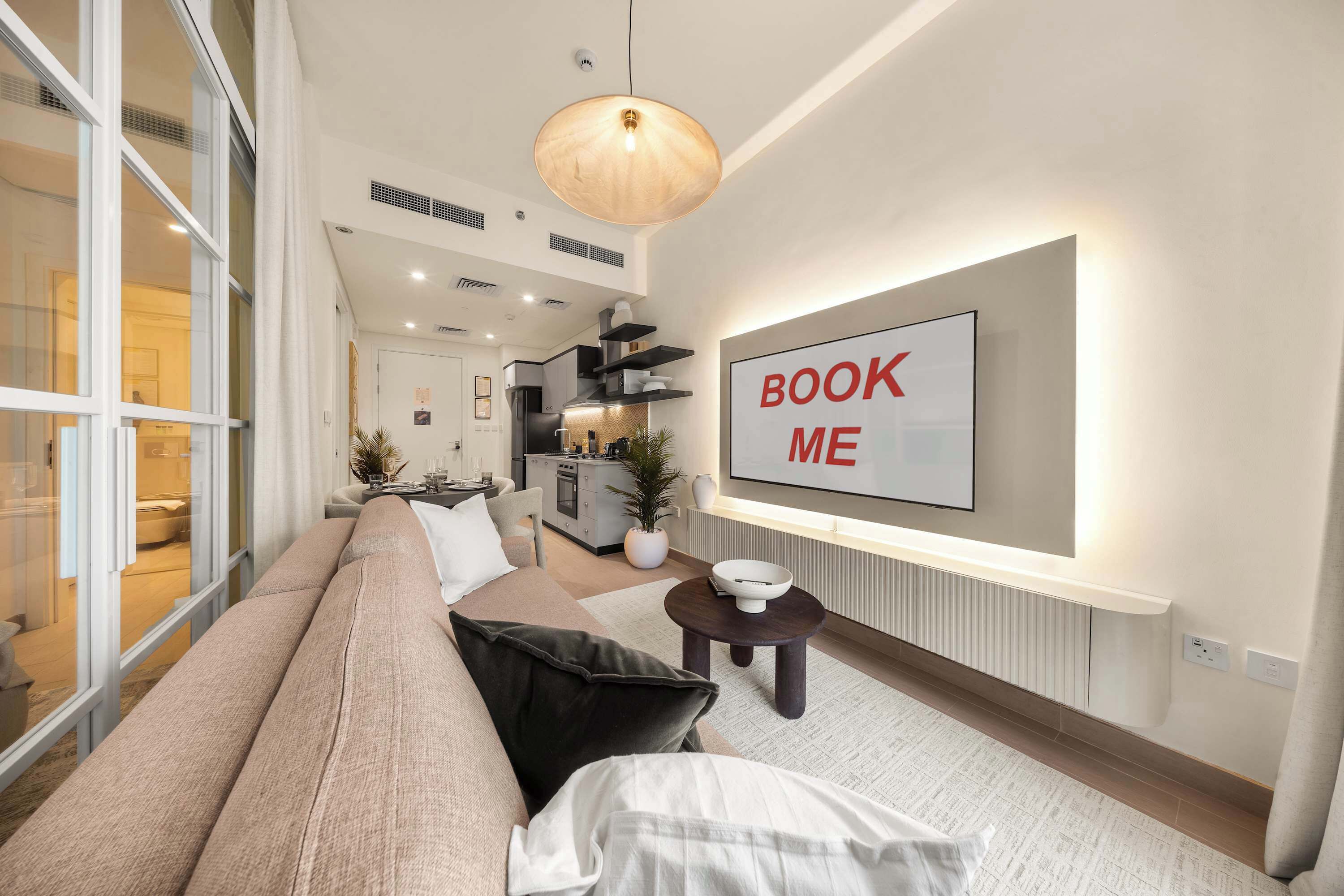Ein modernes Wohnzimmer mit einer Couch, einem Essbereich und einer Küche im Hintergrund.