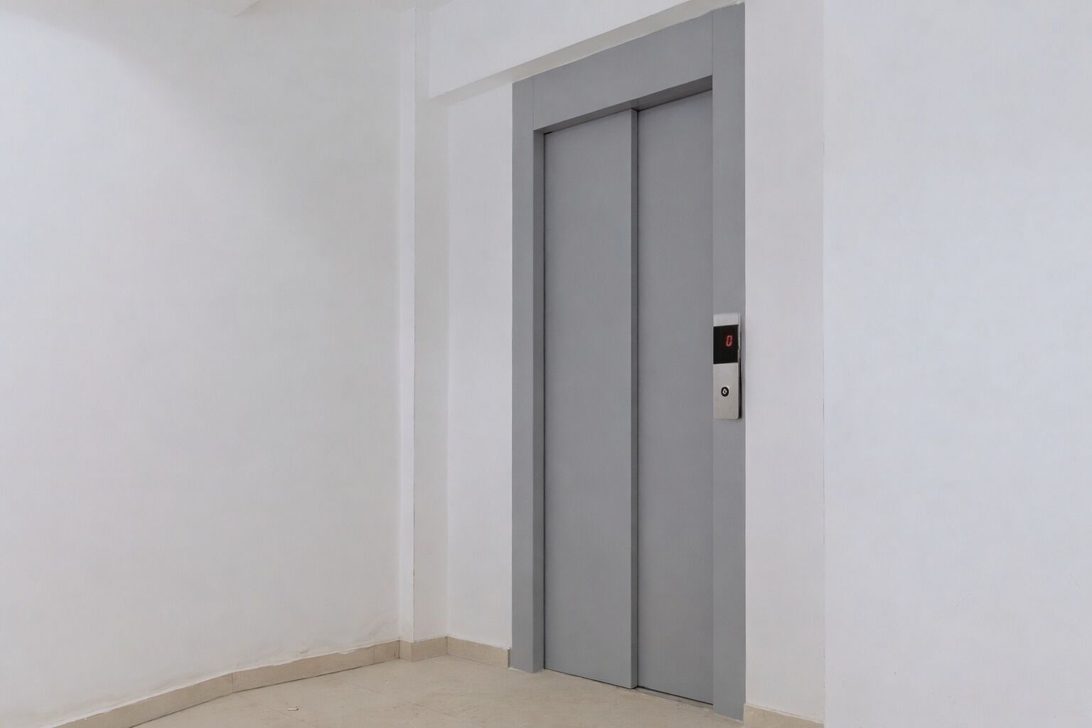 Puerta de ascensor gris y sencilla con un panel digital que muestra el número 0.