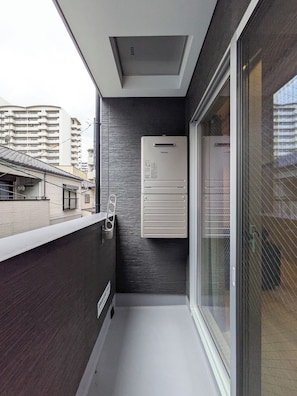 Ein schmaler Balkon mit modernem Design, einer eingebauten Klimaanlage und Blick auf die Stadt.