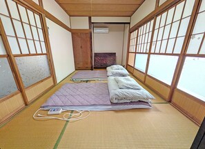 Um quarto japonês tradicional com tatames, painéis shoji e futons.