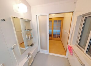 Un bagno moderno con specchio, ripiano e water.