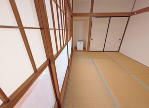 Um quarto japonês tradicional com tatames, portas deslizantes e um pequeno aquecedor.