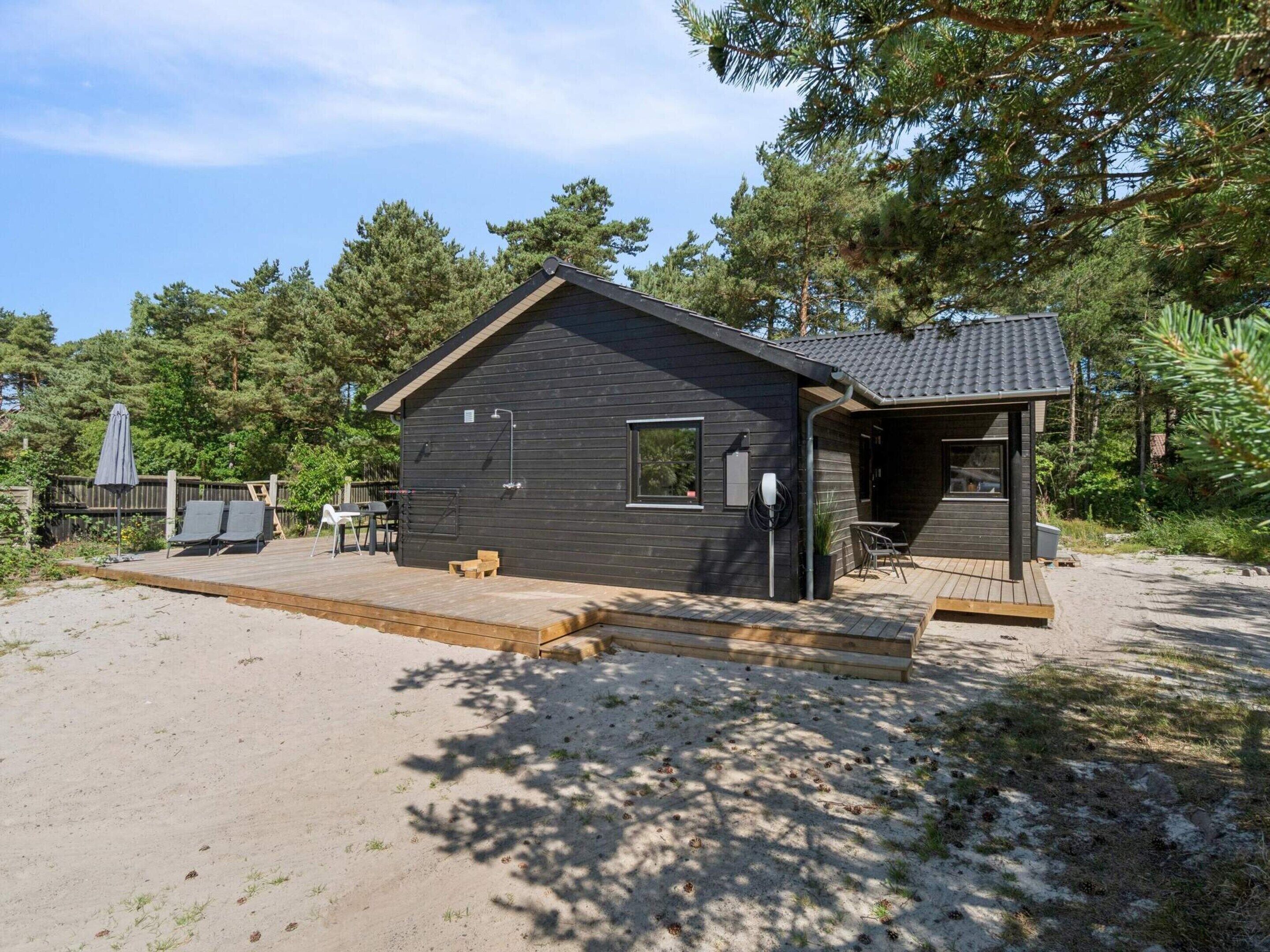 Eine kleine Holzhütte mit einer Holzterrasse und einer kleinen Veranda.