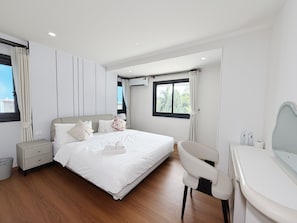 A modern hotel room with a large bed, a desk, a chair, and a view of the outdoors. - POOL Villa KTV BBQ Friends Thepprasit (Muang Pattaya)