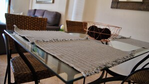 A dining table with a woven placemat, wicker chairs, and a decorative metal basket. - Duplex in Bolnuevo Ideal for Families with Pets (Bolnuevo)