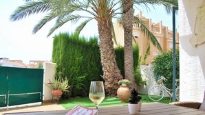 A patio with a table, a glass of white wine, a book, and a bicycle in the background. - Duplex in Bolnuevo Ideal for Families with Pets (Bolnuevo)