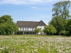A large white building with a tiled roof, surrounded by a field of white flowers and trees. - 5 Star Holiday Home in Tonder (Tonder)