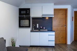 Una cocina compacta equipada con microondas, horno y cocina integrada.