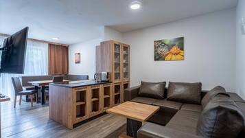 A modern living room with a sofa, a coffee table, a TV, and a wooden cabinet.