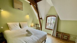 Een slaapkamer met een groot bed, een raam en houten balken.